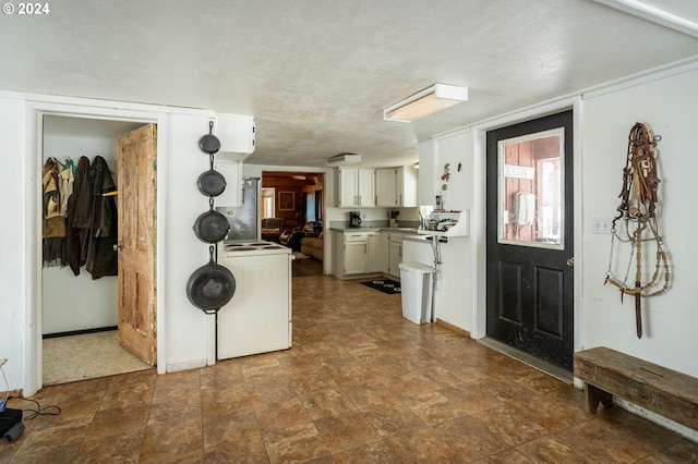 interior space with white cabinets, washer / dryer, and a textured ceiling