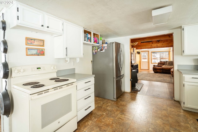 kitchen with white range with electric stovetop, stainless steel refrigerator, white cabinets, and a textured ceiling