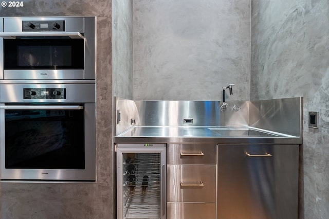 kitchen with stainless steel counters, wine cooler, and stainless steel double oven