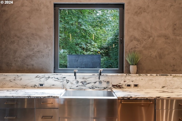 interior space featuring light stone countertops and sink