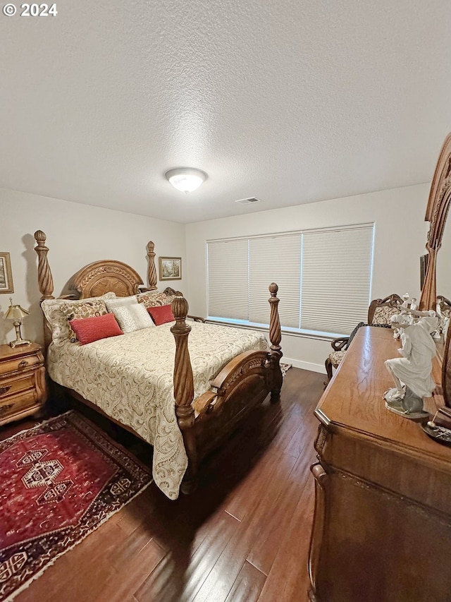 bedroom featuring a textured ceiling and dark hardwood / wood-style floors