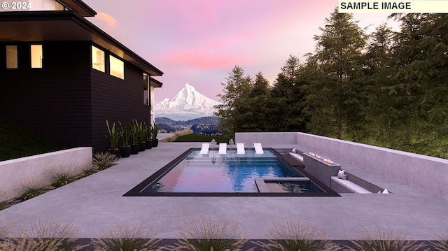 pool at dusk featuring a mountain view