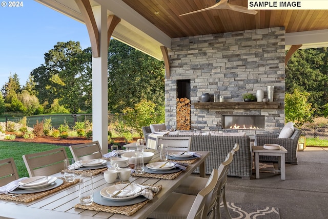 view of patio / terrace with ceiling fan and an outdoor stone fireplace