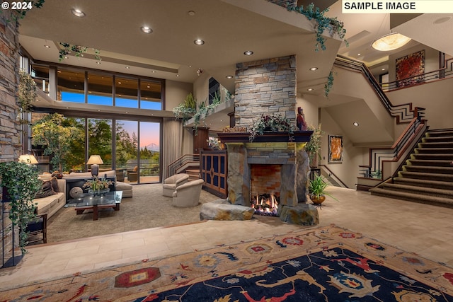 living room featuring a towering ceiling and a stone fireplace