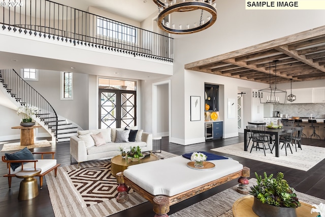 living room with dark hardwood / wood-style flooring, a notable chandelier, and a high ceiling