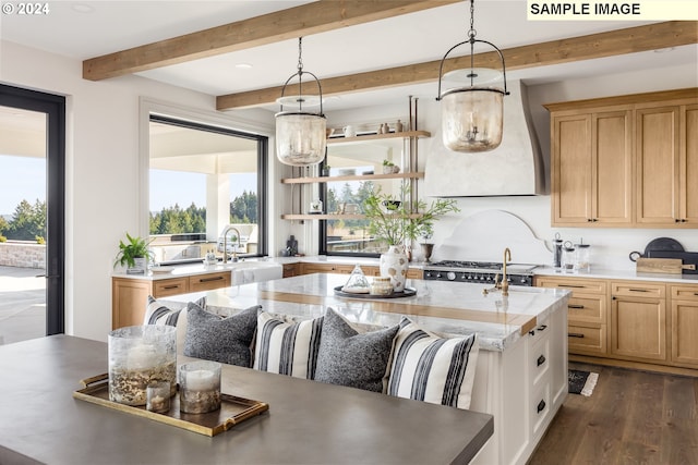 kitchen featuring sink, beam ceiling, an island with sink, dark wood-type flooring, and pendant lighting