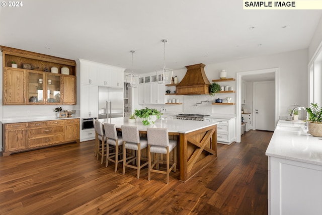 kitchen with white cabinetry, a kitchen breakfast bar, dark hardwood / wood-style flooring, and appliances with stainless steel finishes