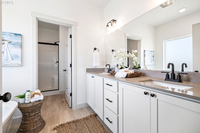 1588 NE 8th Pl, Hermiston, OR 97838 - bathroom with double vanity, wood finished floors, a tub to relax in, and a stall shower
