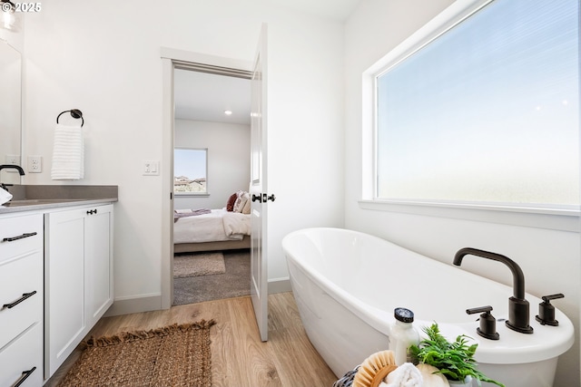 1588 NE 8th Pl, Hermiston, OR 97838 - full bathroom with vanity, wood finished floors, a freestanding bath, and ensuite bathroom