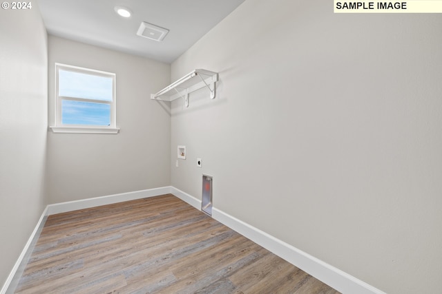 clothes washing area featuring washer hookup, hookup for an electric dryer, laundry area, wood finished floors, and baseboards