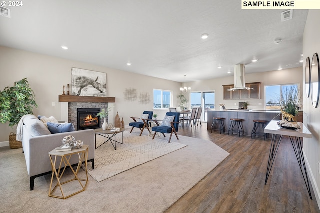 living room featuring visible vents, recessed lighting, a stone fireplace, and wood finished floors