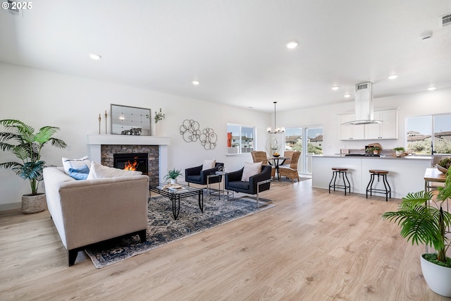 1588 NE 8th Pl, Hermiston, OR 97838 - living area featuring light wood-type flooring, a stone fireplace, and recessed lighting