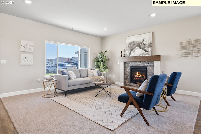 living room featuring recessed lighting, baseboards, a stone fireplace, and wood finished floors