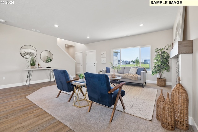 living area with baseboards, recessed lighting, and wood finished floors