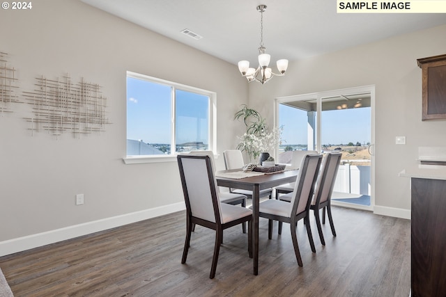 dining space with baseboards, dark wood finished floors, a chandelier, and visible vents