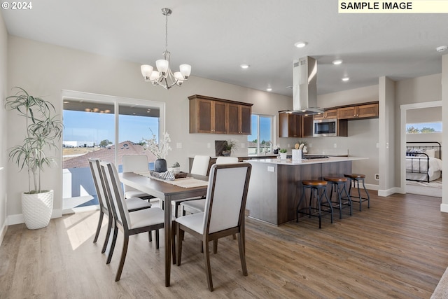 dining area featuring baseboards, recessed lighting, wood finished floors, and a notable chandelier