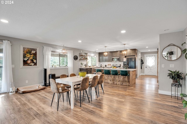 dining area with light hardwood / wood-style floors and a textured ceiling