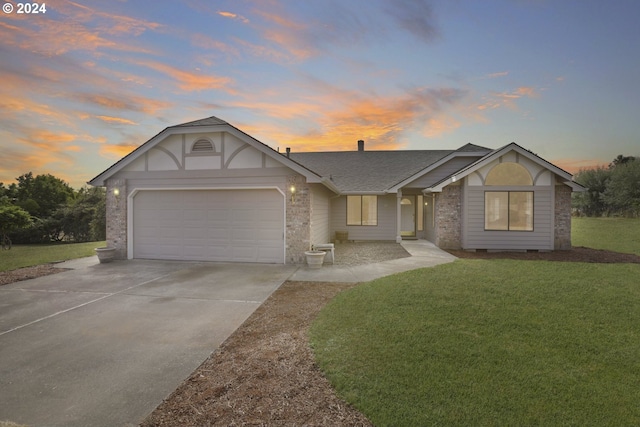 view of front of house featuring a garage and a lawn