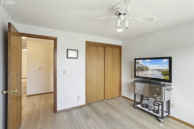 bedroom with ceiling fan, light hardwood / wood-style flooring, and a closet