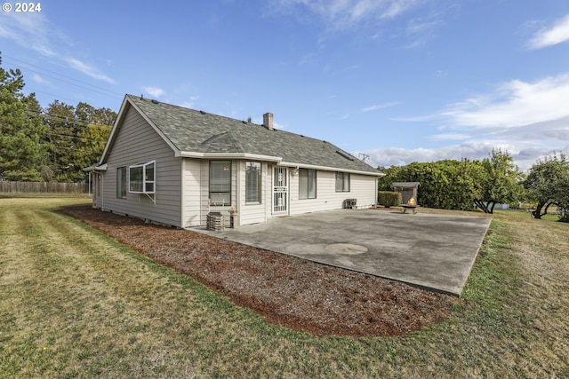 back of house with a lawn and a patio