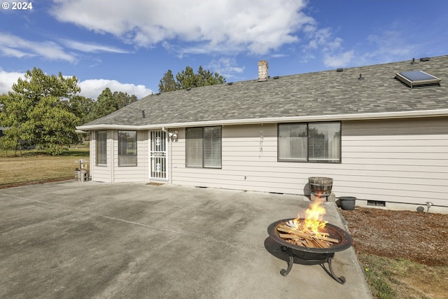 back of property with a patio area and a fire pit