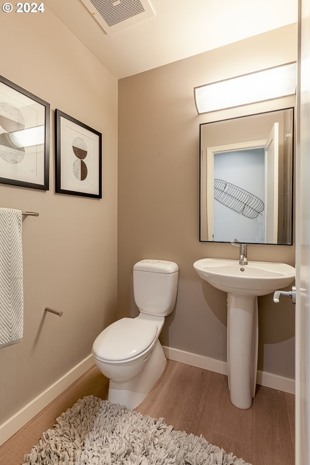 bathroom with sink, toilet, and hardwood / wood-style flooring