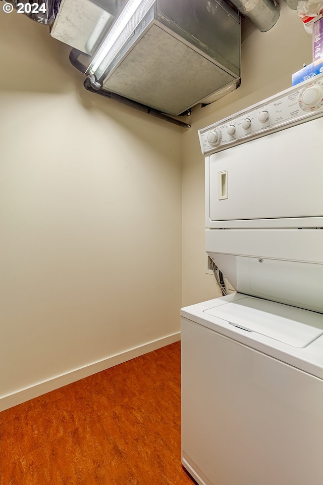 washroom featuring stacked washer / drying machine