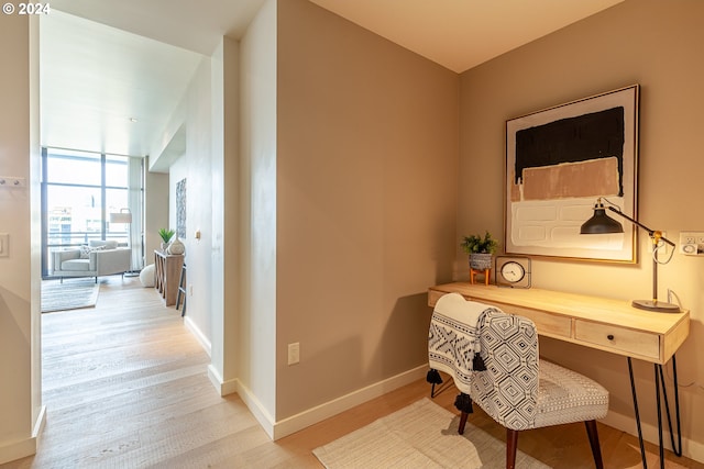 office space with expansive windows and light hardwood / wood-style floors