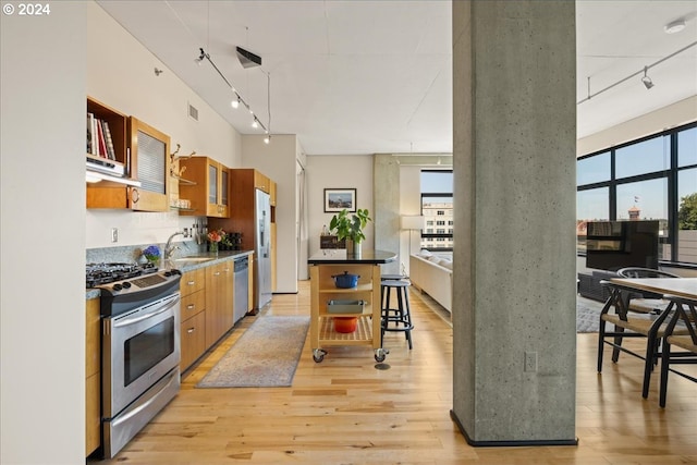 kitchen with stainless steel appliances, rail lighting, and light wood-type flooring