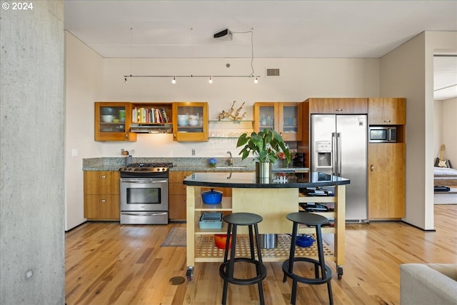 kitchen featuring appliances with stainless steel finishes, sink, and light wood-type flooring