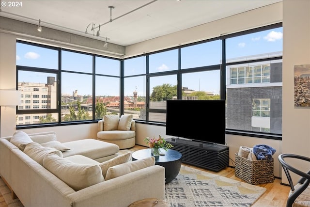 sunroom featuring rail lighting and a wealth of natural light