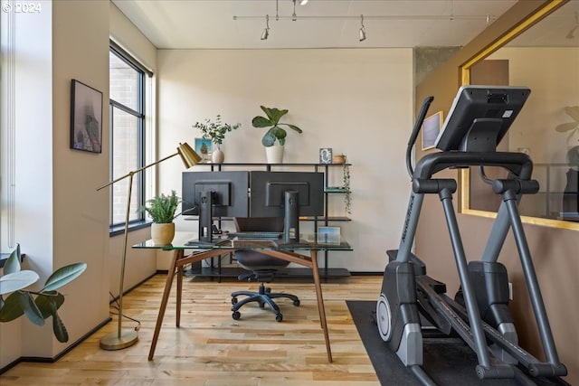 office with track lighting and light hardwood / wood-style floors