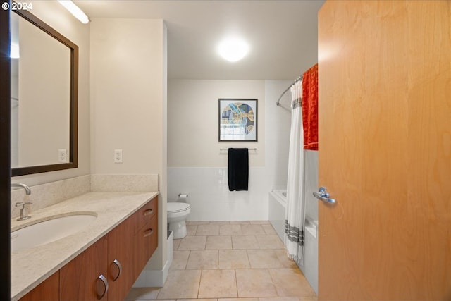 full bathroom featuring tile walls, shower / bath combination with curtain, tile patterned flooring, vanity, and toilet