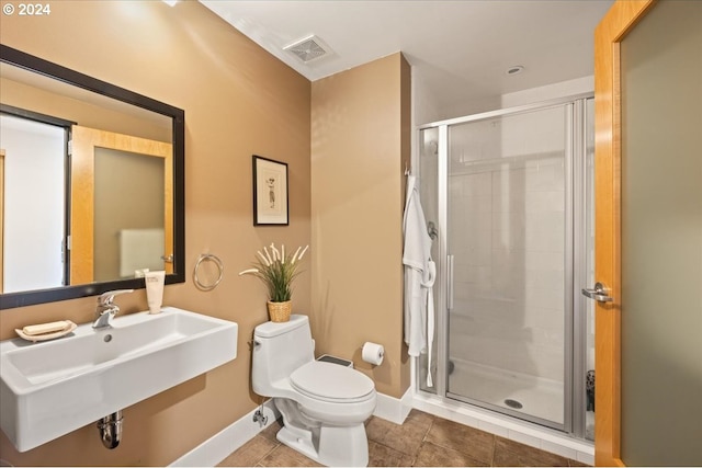 bathroom featuring an enclosed shower, sink, tile patterned floors, and toilet