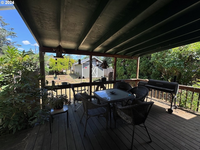 wooden terrace featuring a grill and a shed