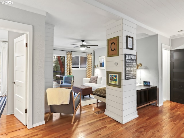 living area featuring wood-type flooring and ceiling fan