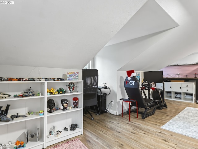 interior space with vaulted ceiling and light hardwood / wood-style flooring