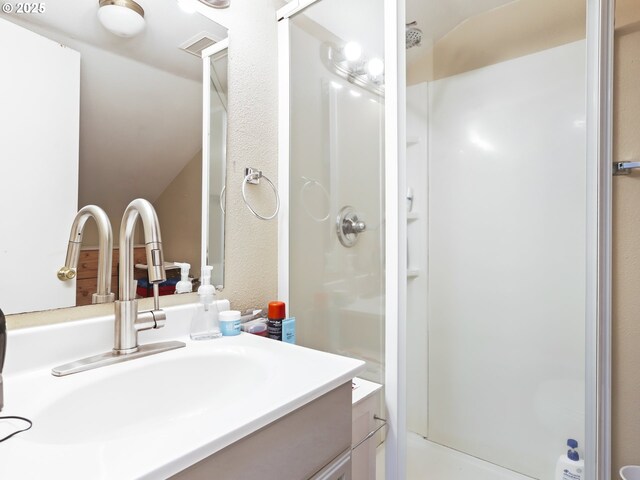 bathroom with vanity and a shower with shower door