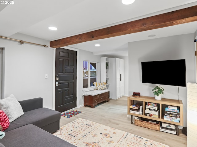 living room with light hardwood / wood-style floors and beam ceiling