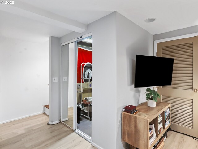 interior space featuring beam ceiling and light hardwood / wood-style flooring