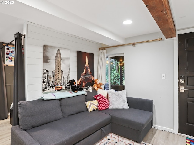 living room featuring beamed ceiling and light hardwood / wood-style floors