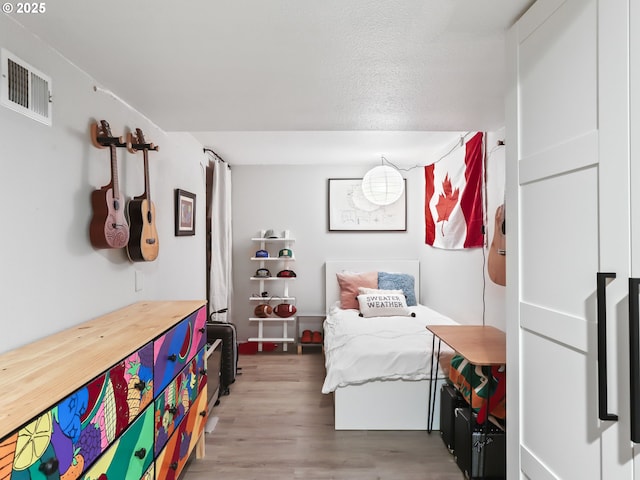 bedroom featuring hardwood / wood-style flooring and a textured ceiling