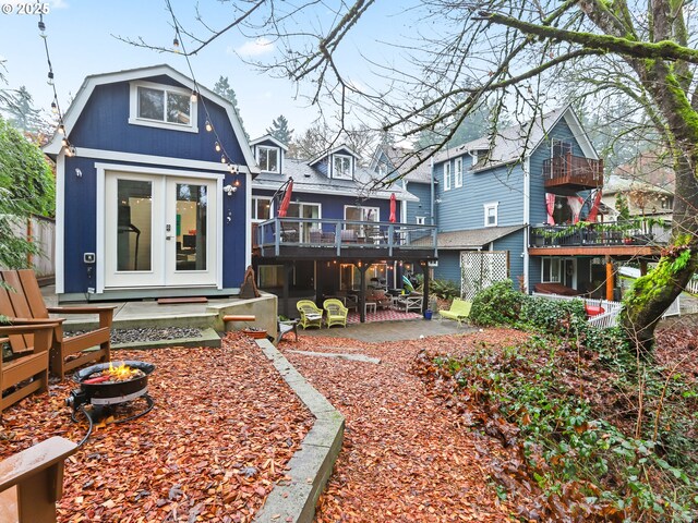 rear view of house with a patio area, french doors, and a deck