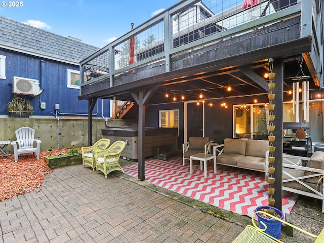 view of patio featuring a wall mounted air conditioner, an outdoor living space, and a hot tub