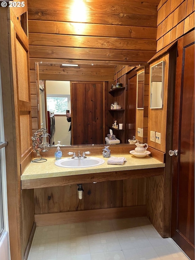 bathroom with sink and wood walls