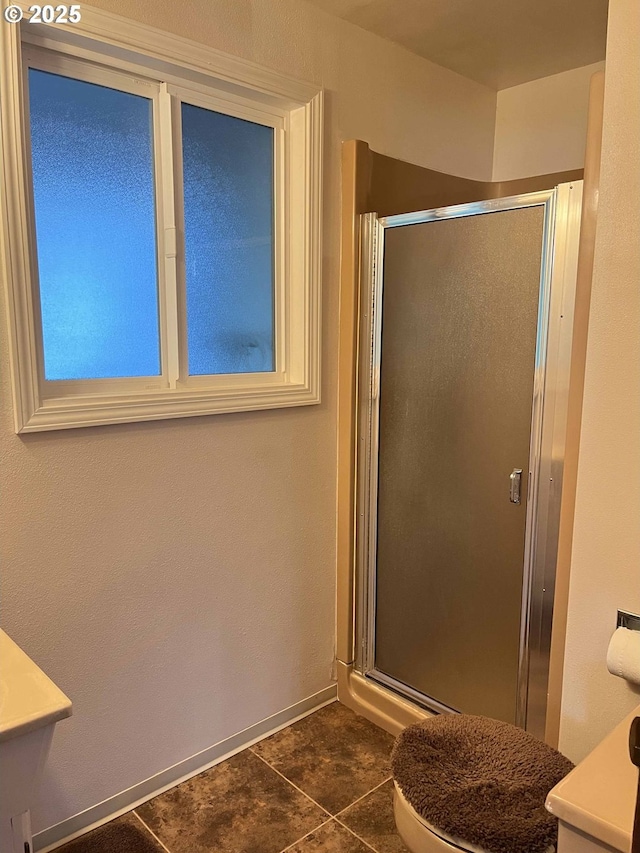 bathroom with an enclosed shower and tile patterned floors