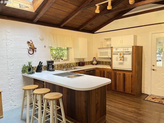 kitchen with wooden ceiling, kitchen peninsula, lofted ceiling with skylight, and white appliances