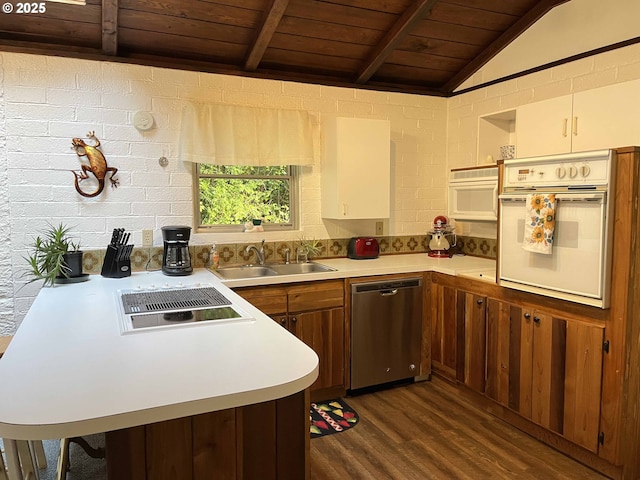 kitchen featuring dishwasher, oven, kitchen peninsula, lofted ceiling with beams, and sink