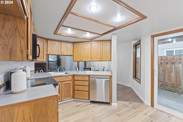 kitchen with light hardwood / wood-style floors, sink, stainless steel dishwasher, and kitchen peninsula