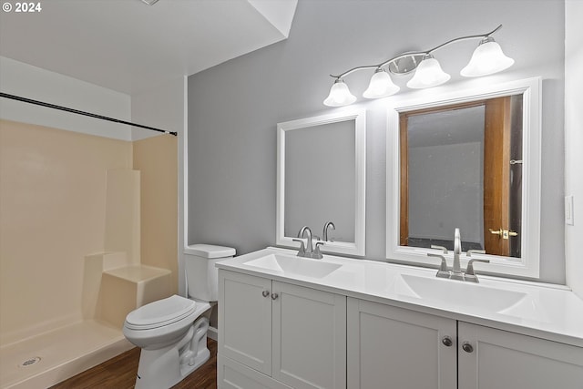 bathroom with a shower, hardwood / wood-style flooring, vanity, and toilet